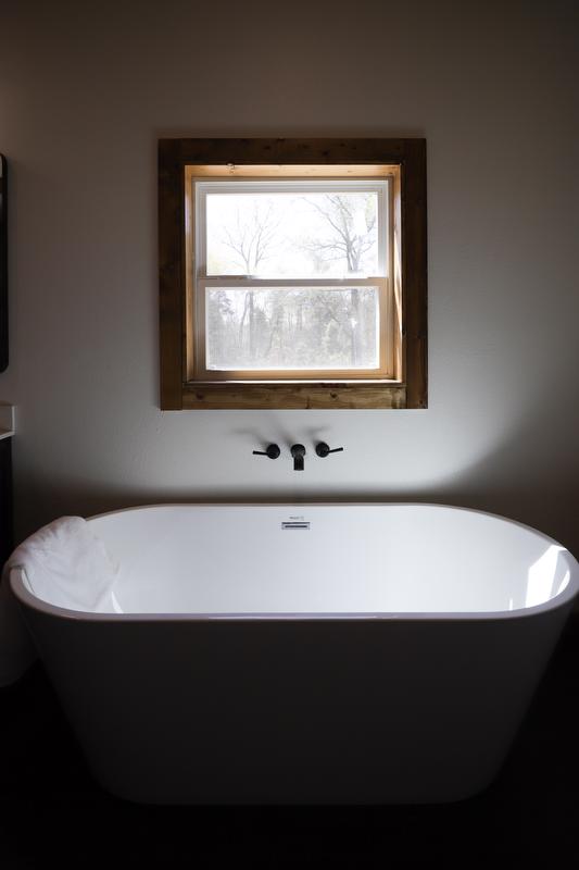 Freestanding tub under window.