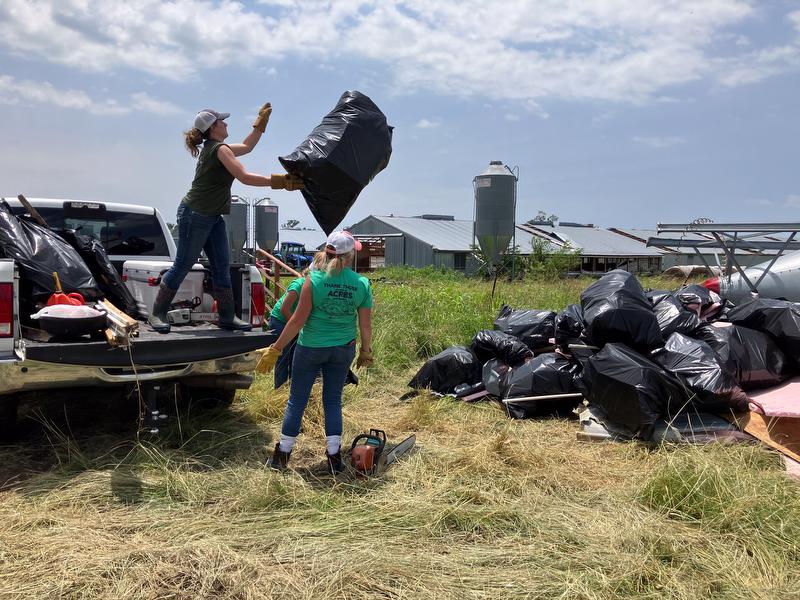 Employees gather bags of debris