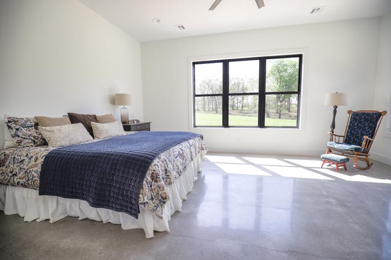 Bedroom area with bed, chair, and large window