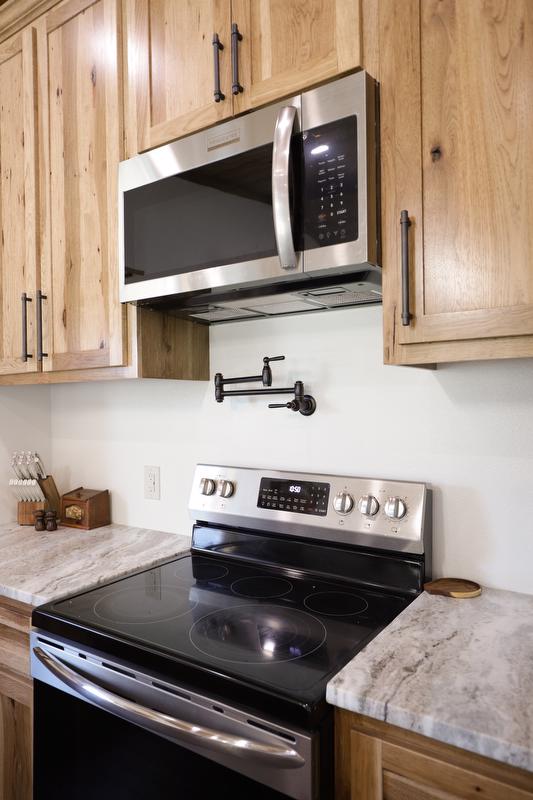 Microwave, pot filler, and stove in kitchen