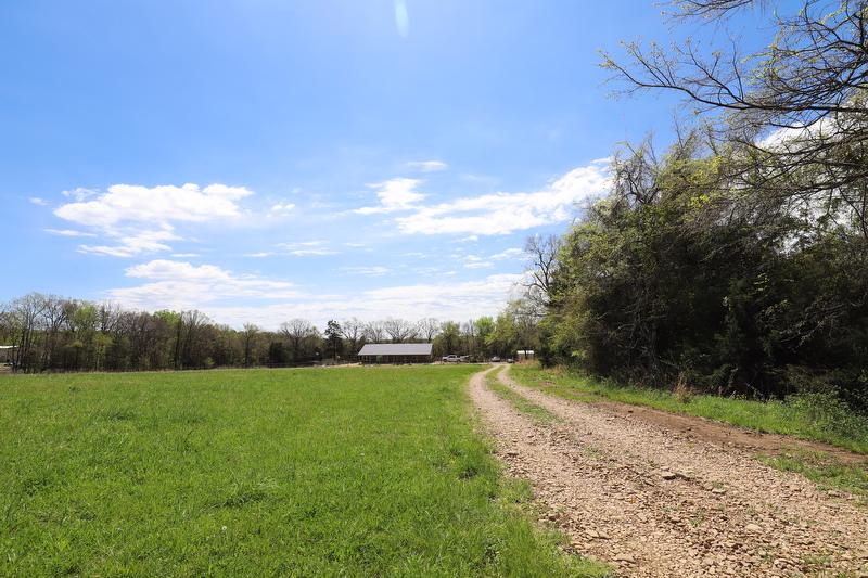 Wide view of field with house in the distance.