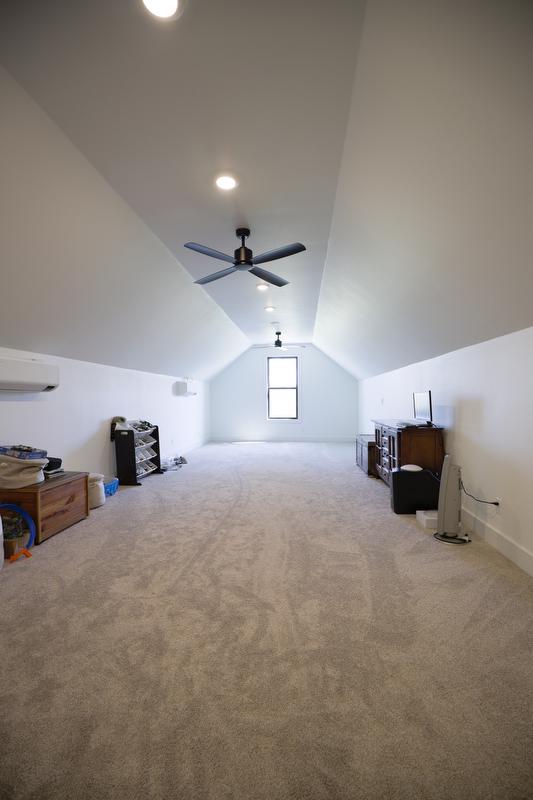 Long bonus room space with gray carpet and angled ceiling