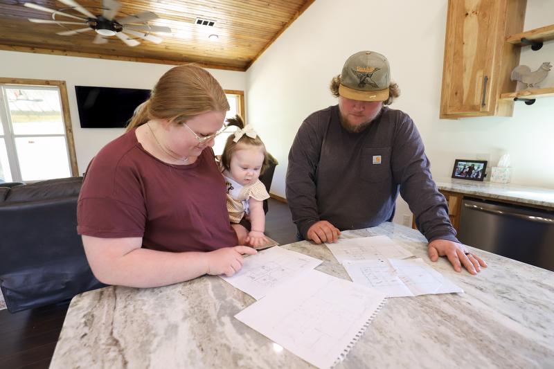 Emilie, Hattie, and Austin look over their original building plans at the kitchen island