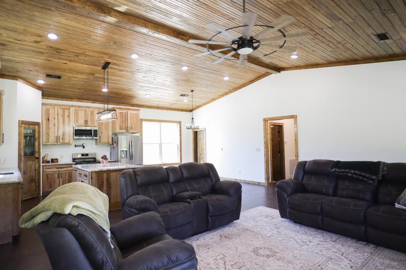 Living room area with couches with kitchen area in background