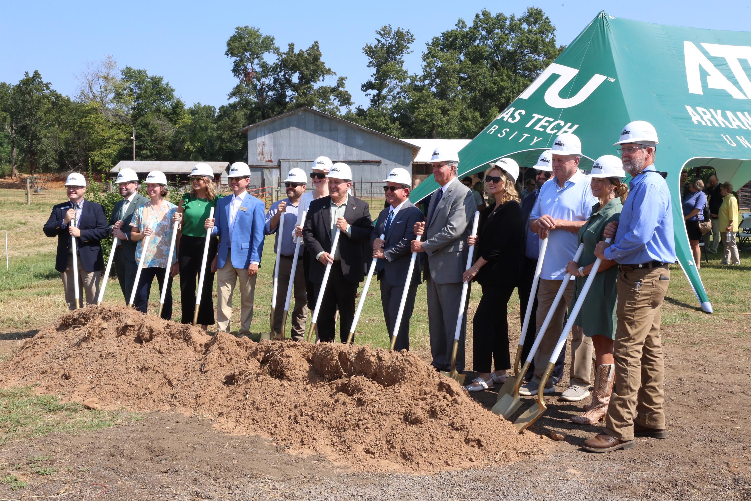 Group of people wearing hard hats and holding shovels get ready to break ground on new agriculture building at Arkansas Tech.